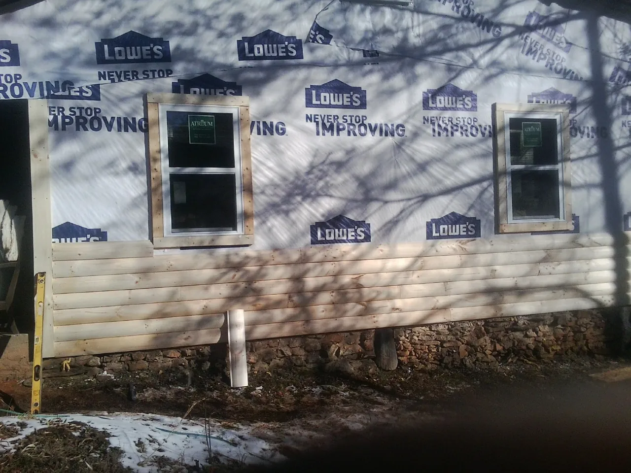 House wrap and new log siding going up on an exterior wall in Summerdale
