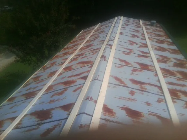 Rusted metal roof panels with new wood purlins before replacement — Storm Damage Roof Repair in Summerdale by Roofing Brothers