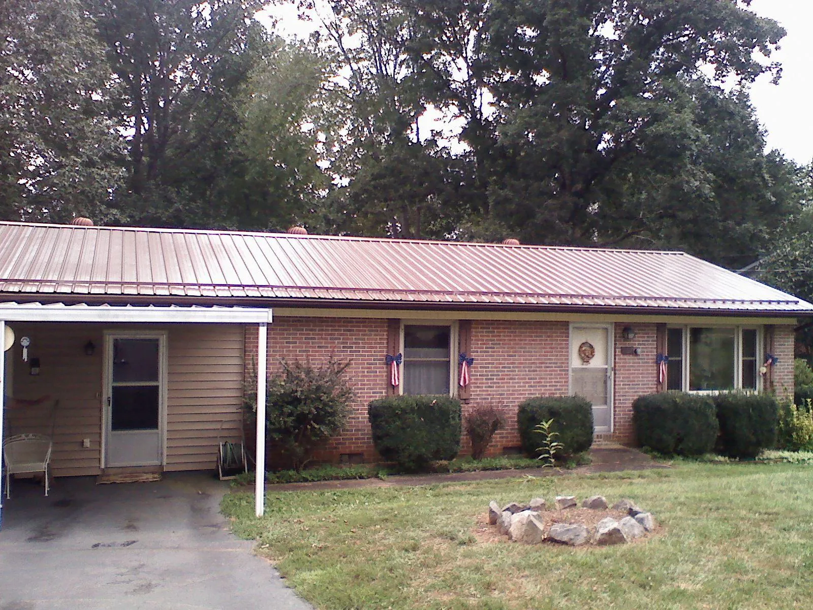 Bronze metal roof and carport on a brick ranch home — Roof Repair work by our crew in Summerdale